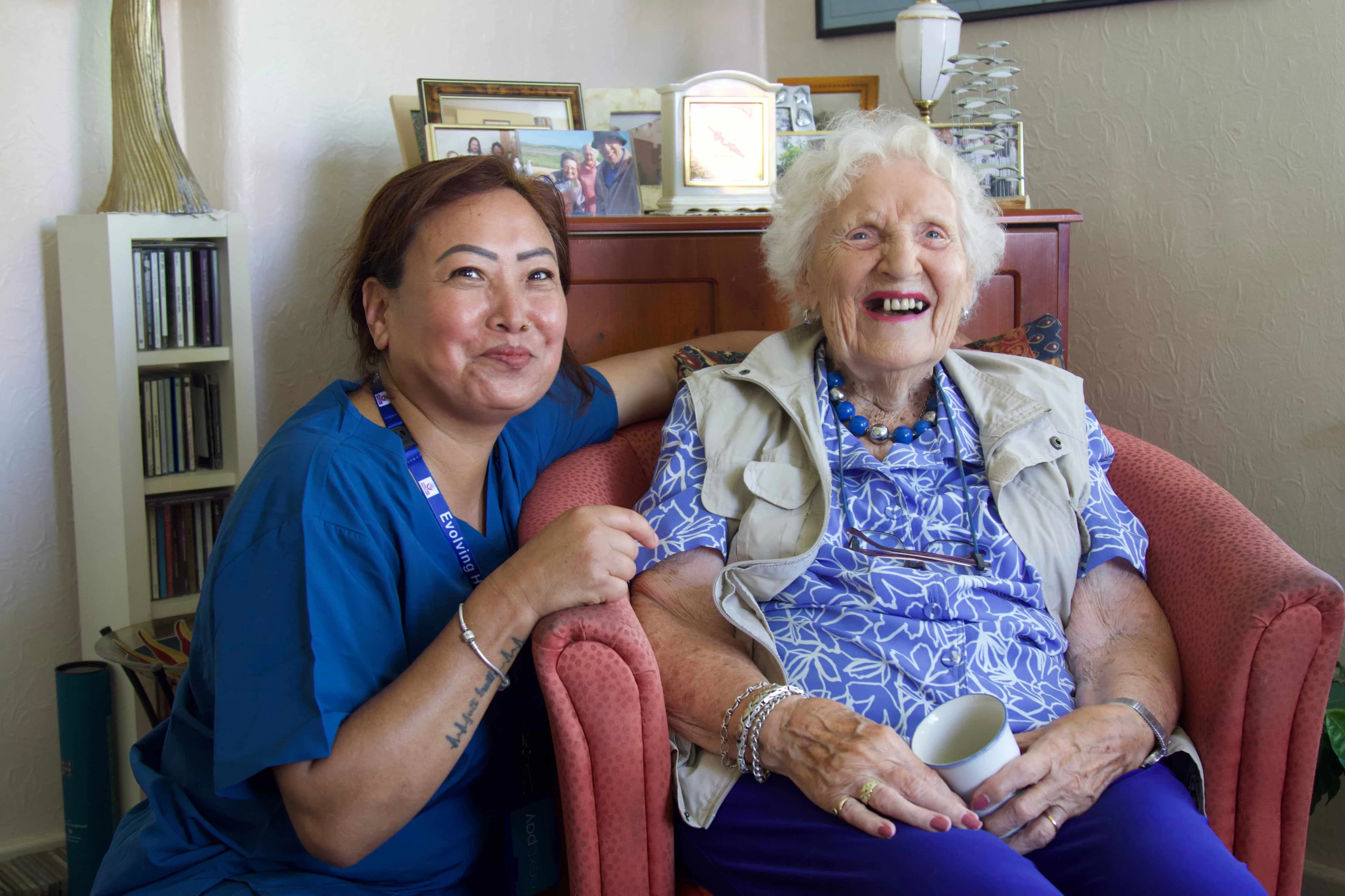 Nurse and elderly resident sharing a happy moment